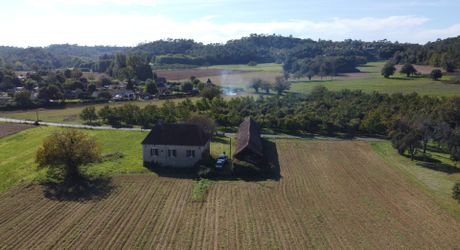 Proche de la rivière Dordogne, entre Sarlat et Souillac, bel ensemble sur deux hectares avec maison principale et grande grange.