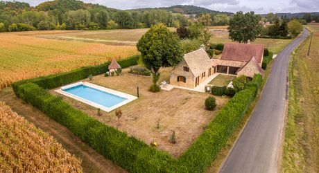 Dans la vallée de la Vézère, patrimoine de l'Unesco, propriété de caractère avec piscine, l'ensemble sur un grand jardin paysagé de 3200 m², avec une très belle vue sur un château.