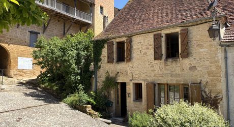 Au pied de la superbe église de Plazac, maison en pierre avec jardin de curé. Très belle affaire.