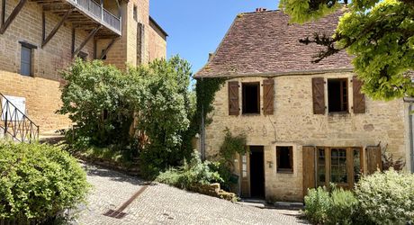 Au pied de la superbe église de Plazac, maison en pierre avec jardin de curé. Très belle affaire.