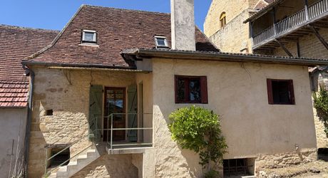 Au pied de la superbe église de Plazac, maison en pierre avec jardin de curé. Très belle affaire.