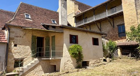 Au pied de la superbe église de Plazac, maison en pierre avec jardin de curé. Très belle affaire.
