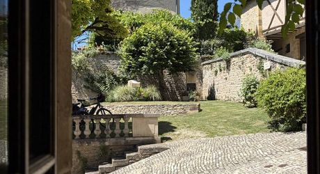 Au pied de la superbe église de Plazac, maison en pierre avec jardin de curé. Très belle affaire.