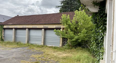En plein centre de Montignac-Lascaux, ensemble comprenant une maison et d'importants bâtiments à destination d'atelier/stockage, avec cour et jardin.