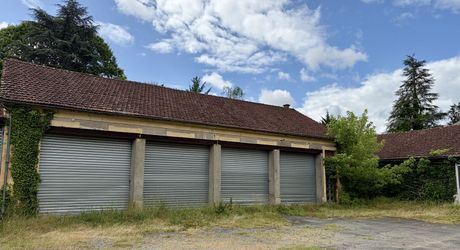 En plein centre de Montignac-Lascaux, ensemble comprenant une maison et d'importants bâtiments à destination d'atelier/stockage, avec cour et jardin.