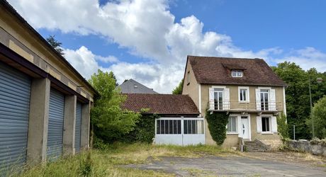 En plein centre de Montignac-Lascaux, ensemble comprenant une maison et d'importants bâtiments à destination d'atelier/stockage, avec cour et jardin.