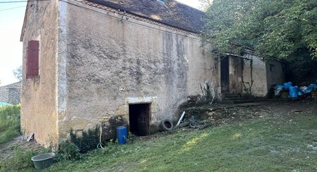 Fermette à rénover avec l'ensemble de ses dépendances agricoles sur 8 ha de terrrain au coeur d'un petit village du Périgord Noir.