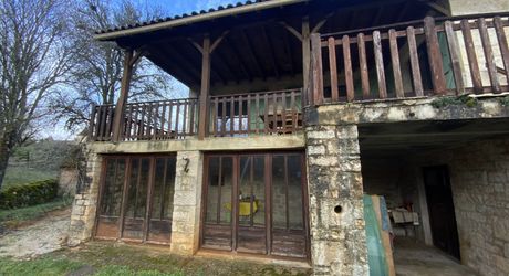 A vendre secteur Gramat, maison familiale en pierre avec terrasse couverte, terrain arboré et dépendances.