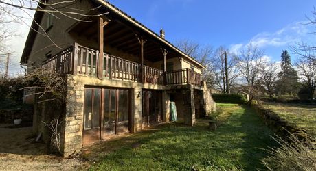 A vendre secteur Gramat, maison familiale en pierre avec terrasse couverte, terrain arboré et dépendances.