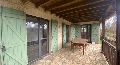 A vendre secteur Gramat, maison familiale en pierre avec terrasse couverte, terrain arboré et dépendances.