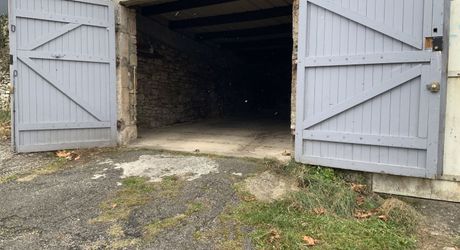 A vendre, grand garage avec jardinet clôturé.