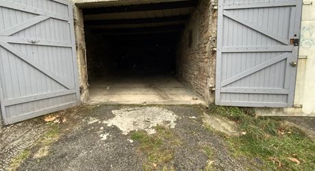 A vendre, grand garage avec jardinet clôturé.