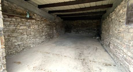 A vendre, grand garage avec jardinet clôturé.