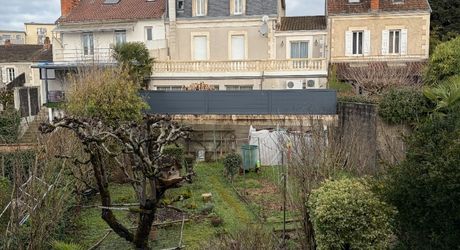 Immeuble de rapport évolutif de 200 m2 habitable avec garages, jardin et potentiel d’aménagement