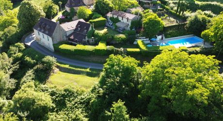 Ensemble en pierre de trois gîtes et une maison principale avec vue panoramique sur la vallée de la Dordogne.