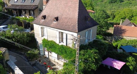 Ensemble en pierre de trois gîtes et une maison principale avec vue panoramique sur la vallée de la Dordogne.
