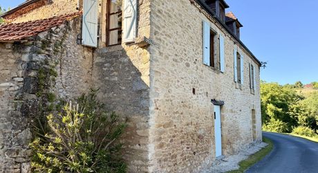 Ensemble en pierre de trois gîtes et une maison principale avec vue panoramique sur la vallée de la Dordogne.