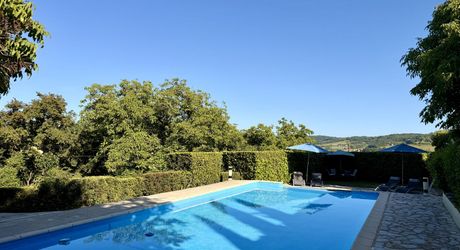 Ensemble en pierre de trois gîtes et une maison principale avec vue panoramique sur la vallée de la Dordogne.