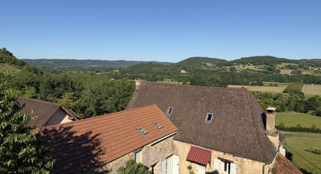 Ensemble en pierre de trois gîtes et une maison principale avec vue panoramique sur la vallée de la Dordogne.
