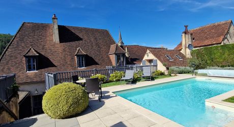 Demeure périgordine rénovée avec piscine et jardin clos dans village avec commerces.