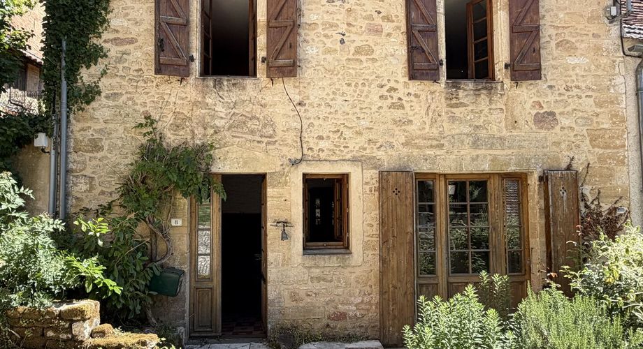 Au pied de la superbe église de Plazac, maison en pierre avec jardin de curé. Très belle affaire.