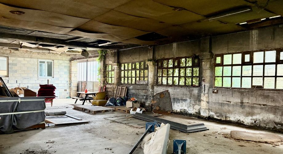 En plein centre de Montignac-Lascaux, ensemble comprenant une maison et d'importants bâtiments à destination d'atelier/stockage, avec cour et jardin.