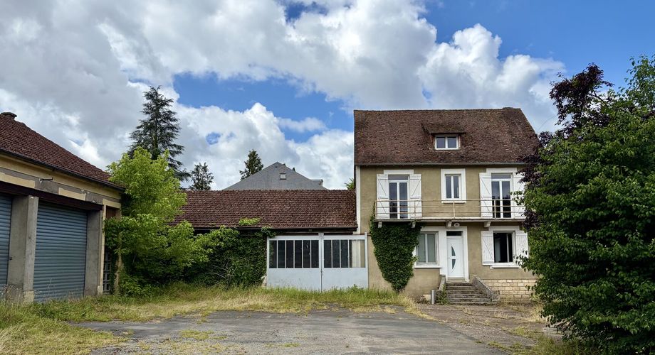 En plein centre de Montignac-Lascaux, ensemble comprenant une maison et d'importants bâtiments à destination d'atelier/stockage, avec cour et jardin.