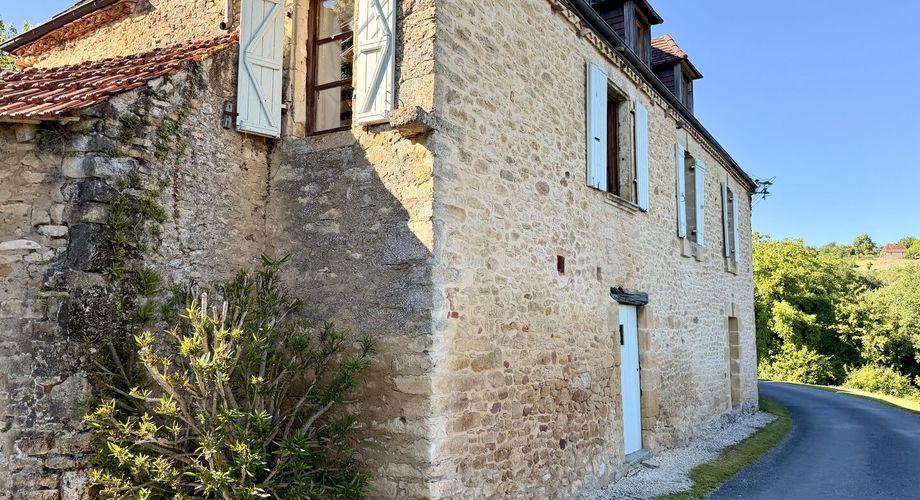 Ensemble en pierre de trois gîtes et une maison principale avec vue panoramique sur la vallée de la Dordogne.
