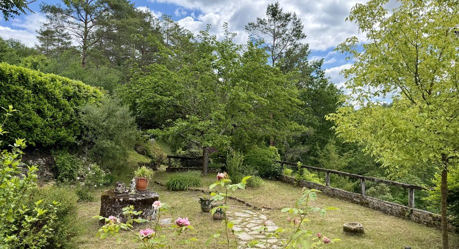 Maison de charme en pierres au coeur du Périgord Noir avec 11 hectares de terrain et un golf accessible à pied.